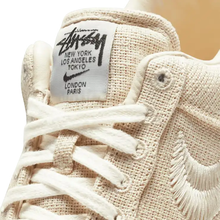 Tênis Bege Nike Air Force 1 Stussy Fossil Vista Frontal da Logo Stussy na Etiqueta