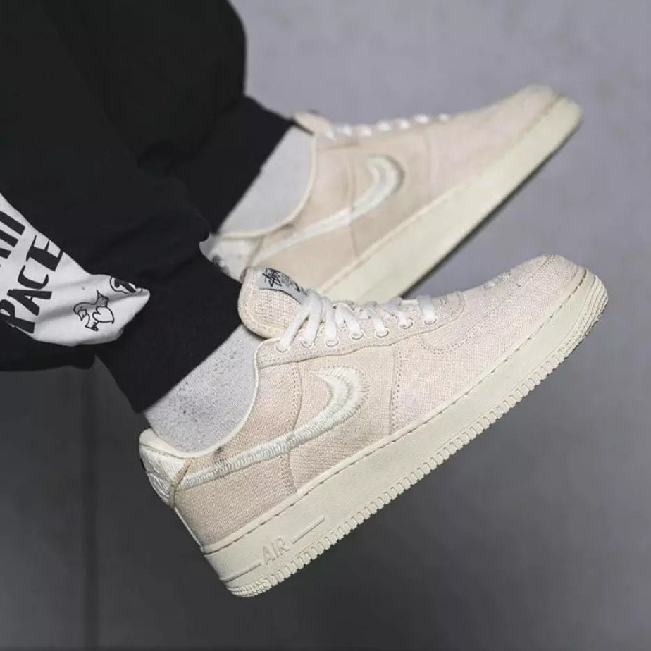 Tênis Bege Nike Air Force 1 Stussy Fossil Visto no Pe com Calca Preta