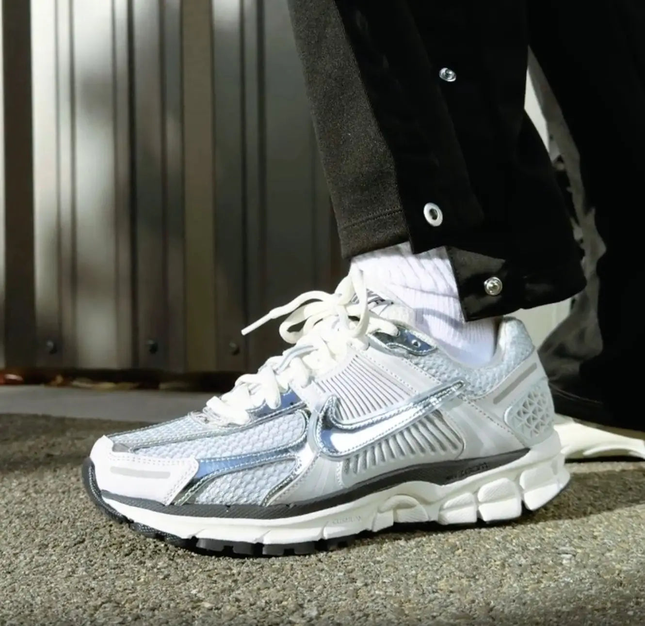 Tênis Branco com Metalico Nike Zoom Vomero 5 Photon Dust Metallic Silver Visto no Pe com Calca Preta e Meia Branca