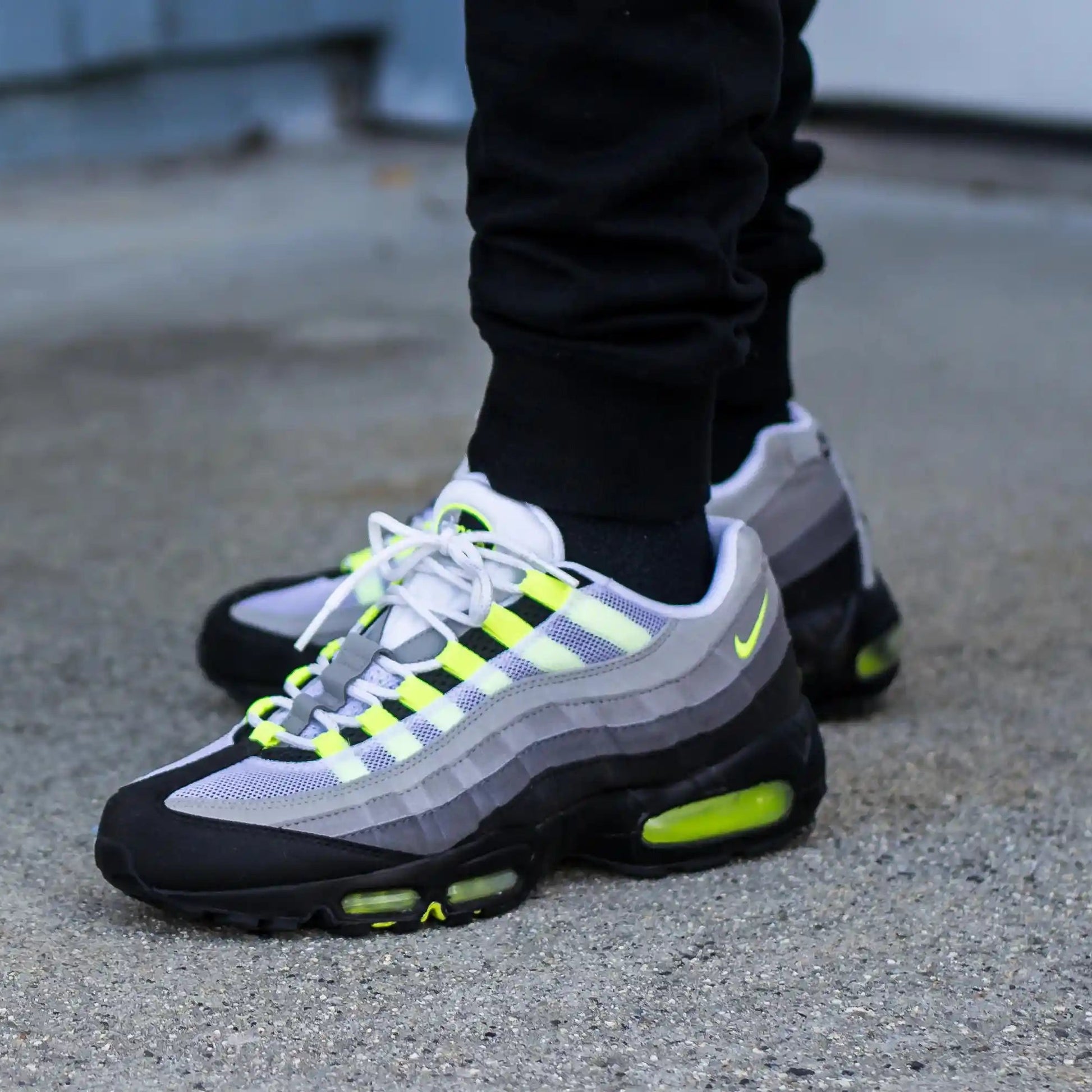 Tênis Cinza com Neon Nike Air Max 95 OG Neon Visto no Pe com Calca Preta