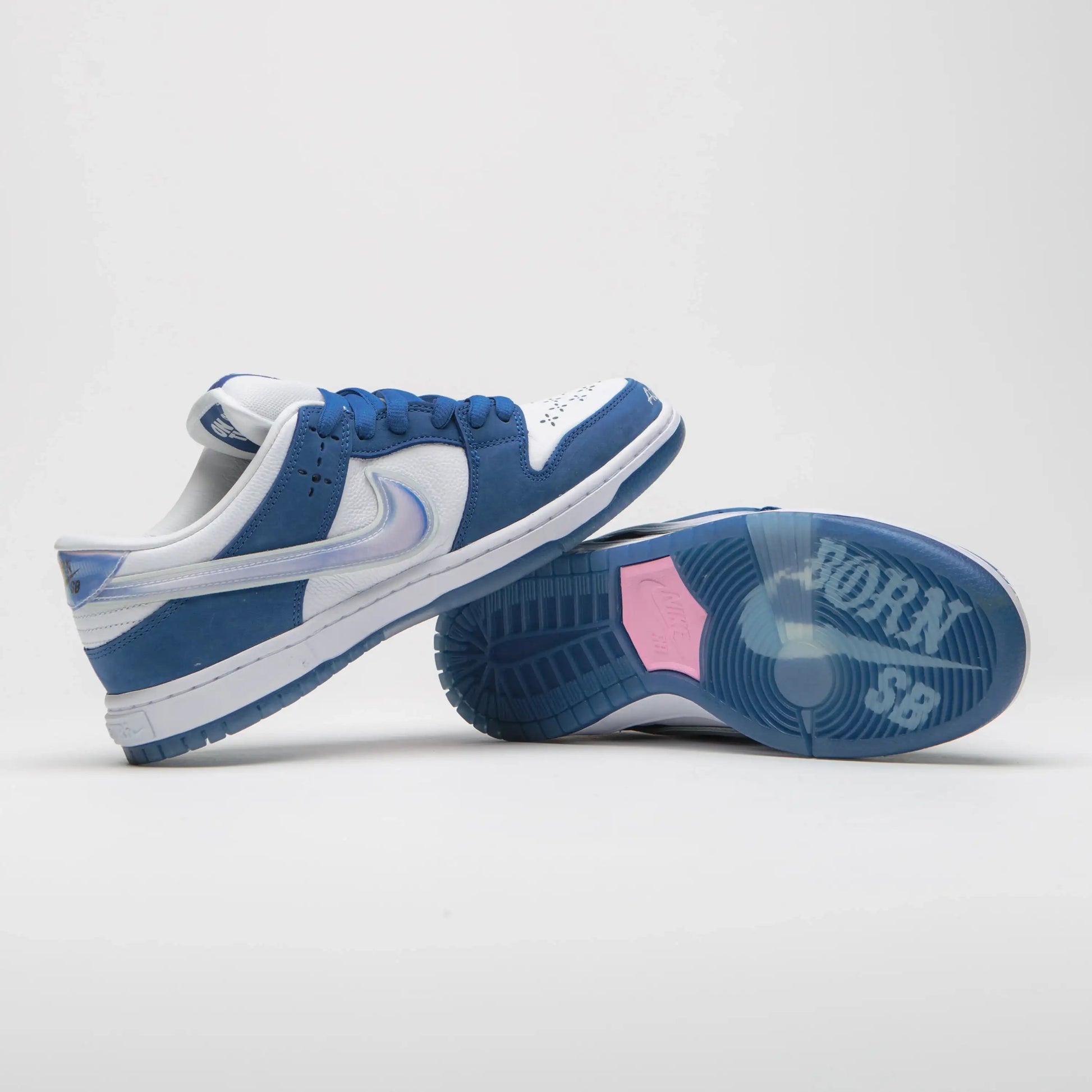 Tênis Nike Azul Dunk Low Born x Raised Block At a Time Um em Cima do Outro Mostrando o Solado Azul Escrito Born SB