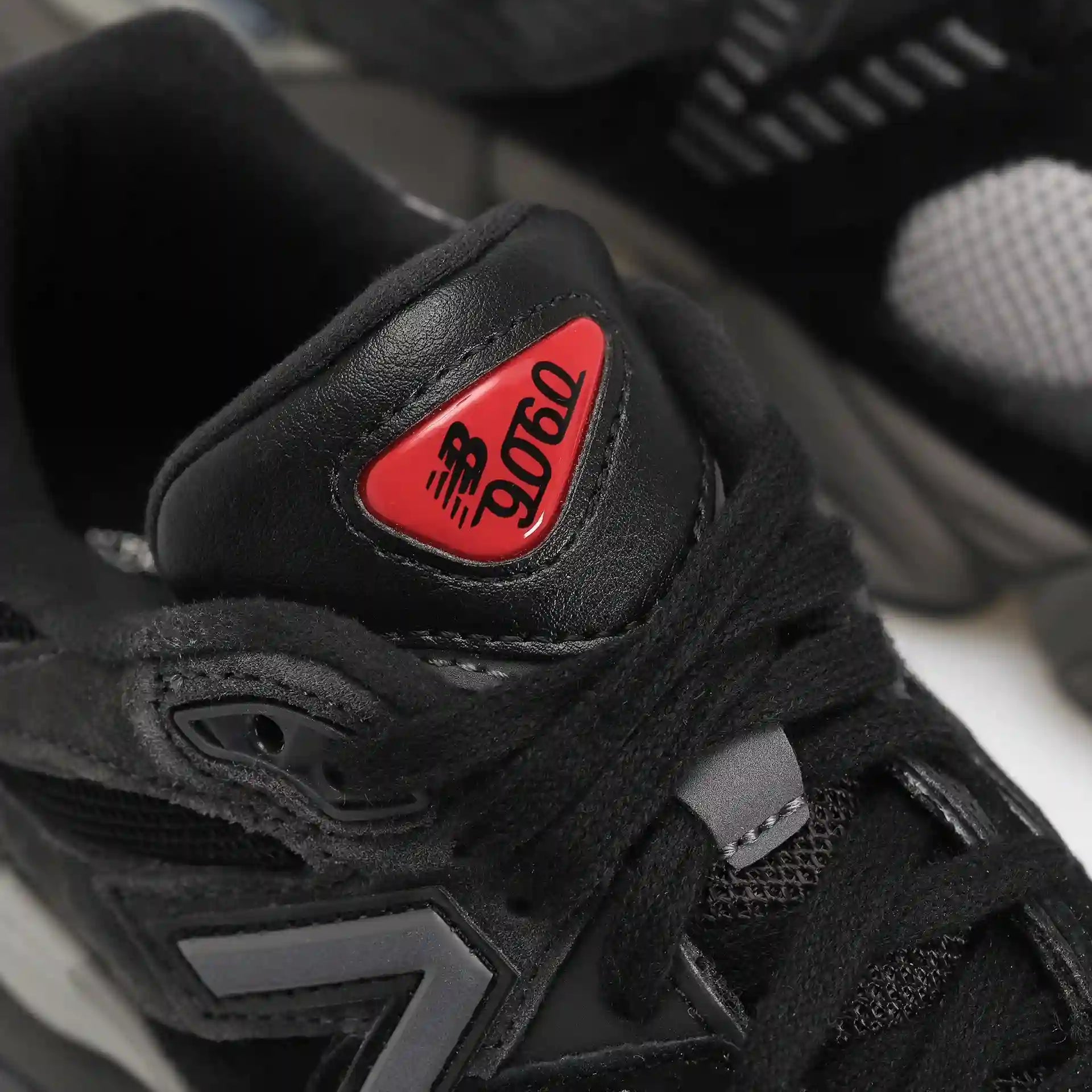Tênis Preto New Balance 9060 Black Castlerock Parte do Cabedal em Detalhes com a Logo NB 9060 Vermelho