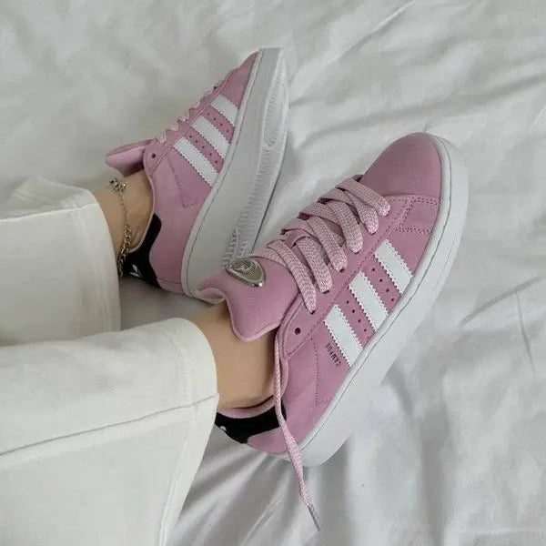 Tênis Rosa Adidas Campus 00s Bliss Lilac Par Visto no Pe de uma Muher com Calca Bege