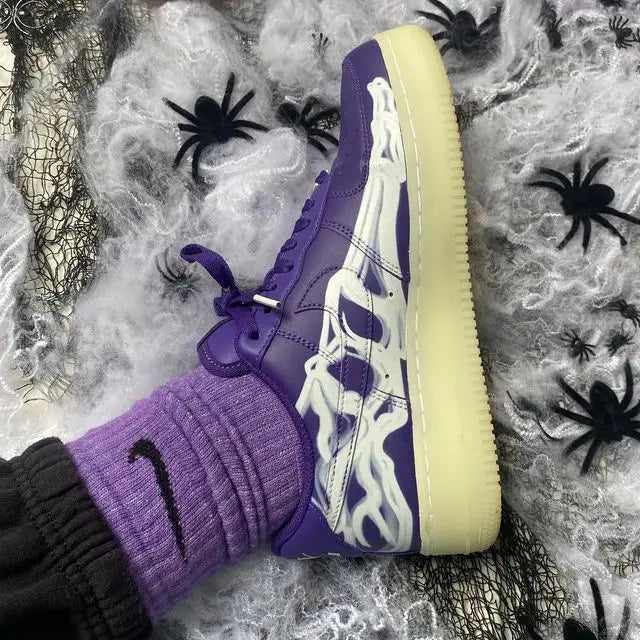 Tênis Roxo Nike Air Force 1 Skeleton Purple Visto por Cima no Pe Com Algumas Teias de Aranha e Aranhas Ficticias ao Lado