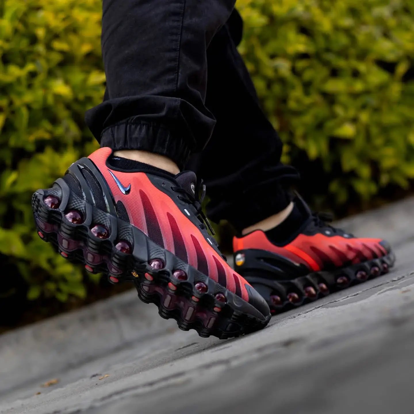 Tênis Vermelho com Preto Nike Air Max Dn8 Black Bright Crimson Visto no Pe com Calca Preta